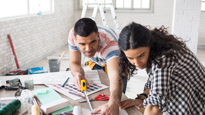 Hispanic couple working together on a home renovation.