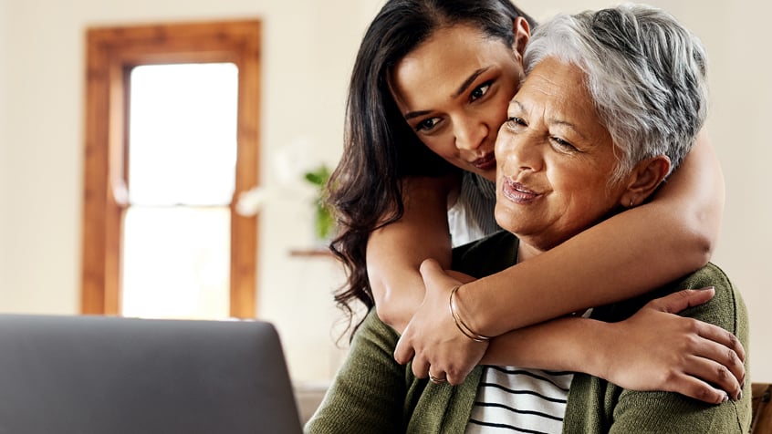 granddaughter hugging grandmother from behind