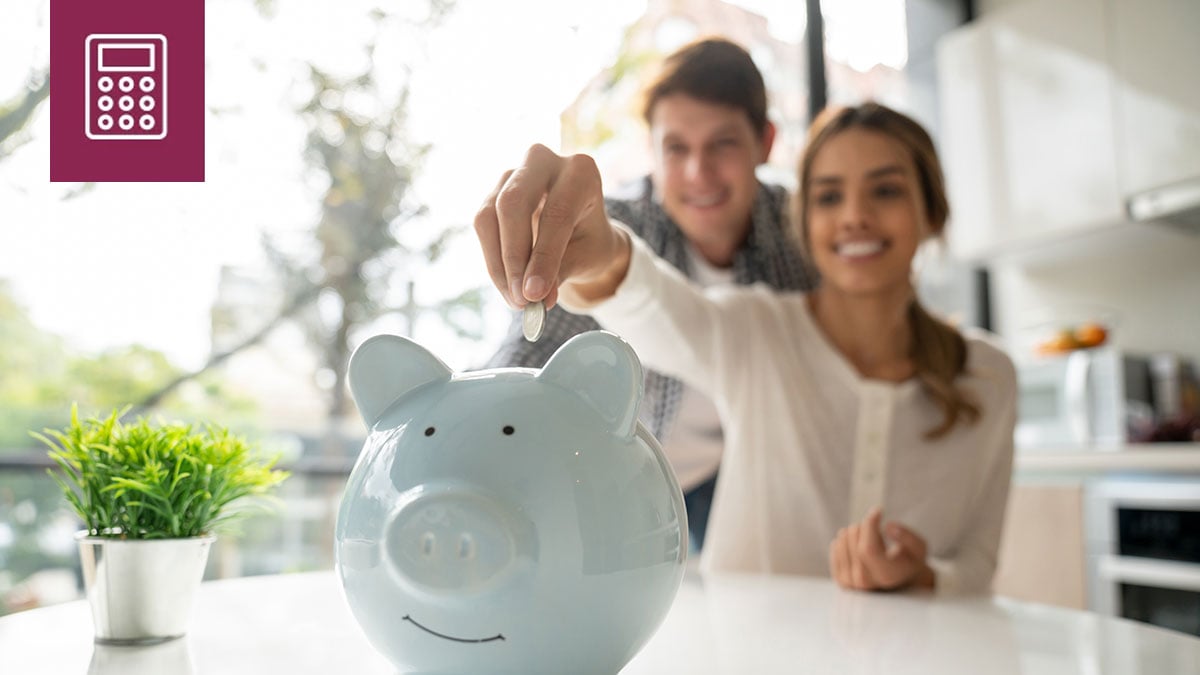 Young couple putting coins into a piggy bank.