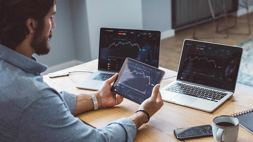 business man looking at charts on a tablet at his desk.