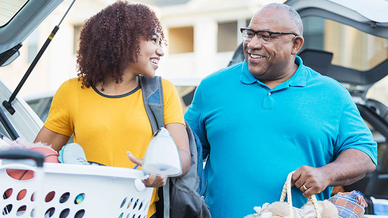 A father helps his daughter move into her college dorm.