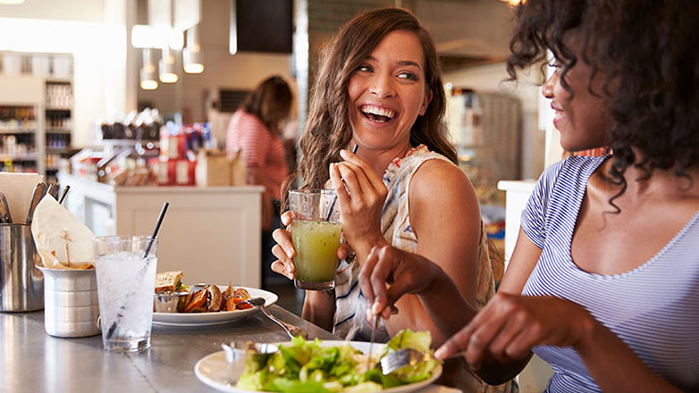 Two female friends grab lunch together at a restaurant.