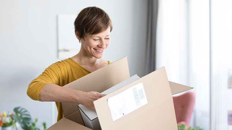 Woman starting a new job and unpacking her boxes at her desk.