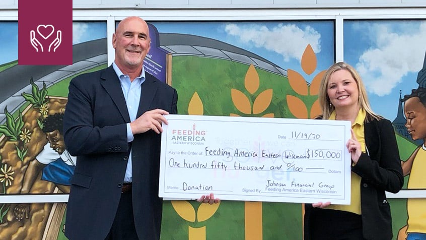 Jim Popp giving a cardboard check to Feeding America.