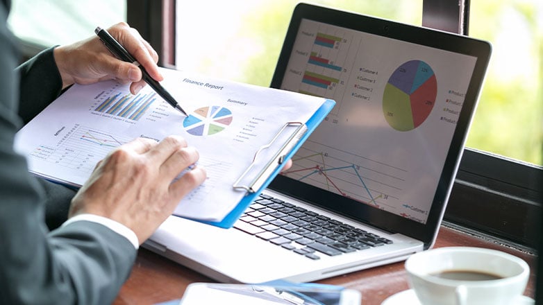 close up of hands looking at finance reports and presentation