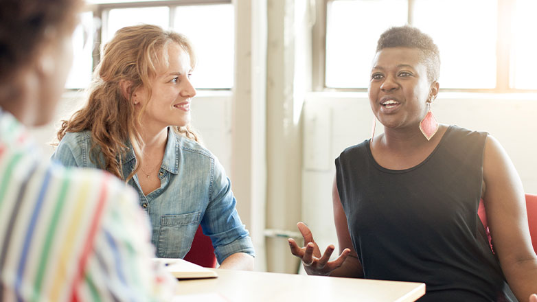 female employees conversing around business table