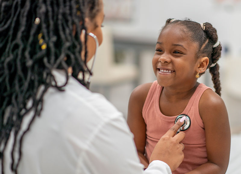 Doctor checks a little girl's heart rate during her appointment.