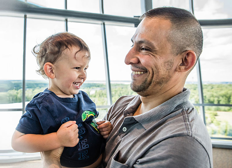 Dad holding baby son in an atrium.