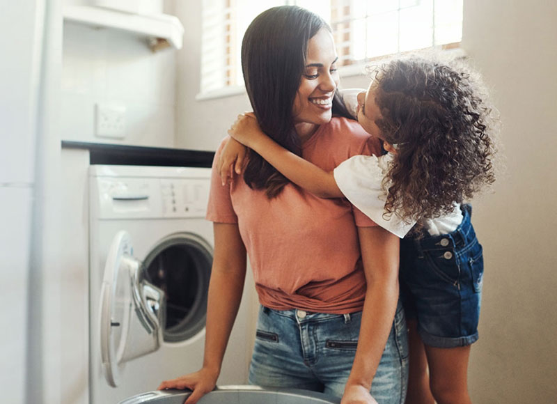 Mom and daughter playing in the laundry room.