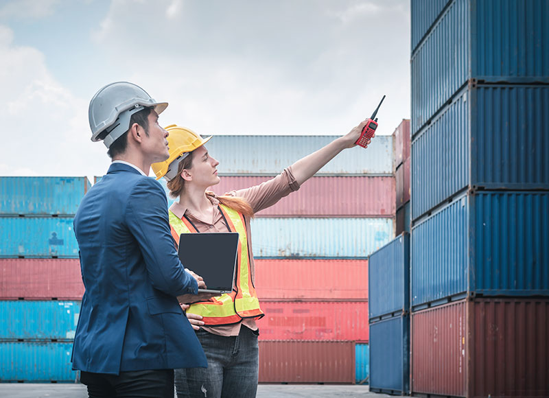 Employee gives business owner a tour of the shipping yard.