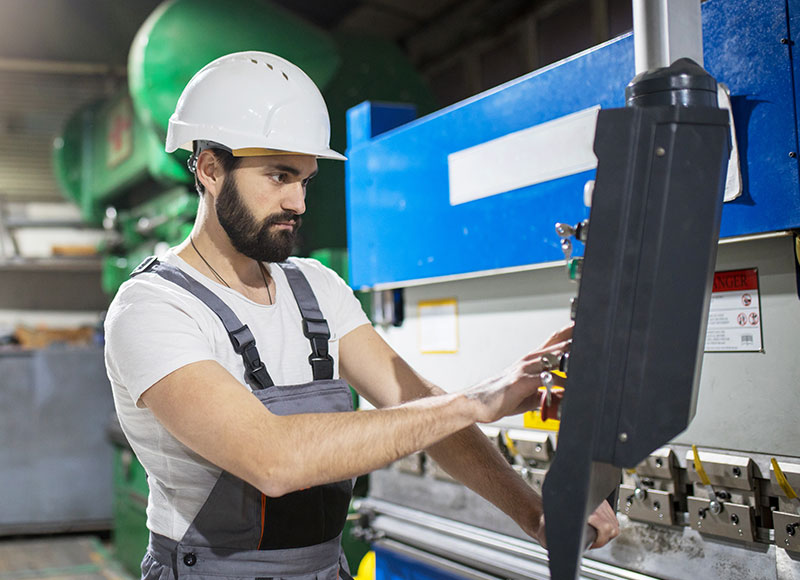 An engineer works on a machine in a manufacturing facility.